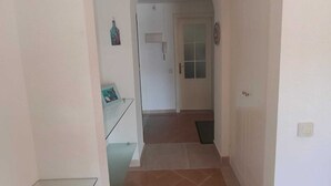 Ein Korridor mit einer gewölbten Decke, der zu einer Tür mit Fenster führt.