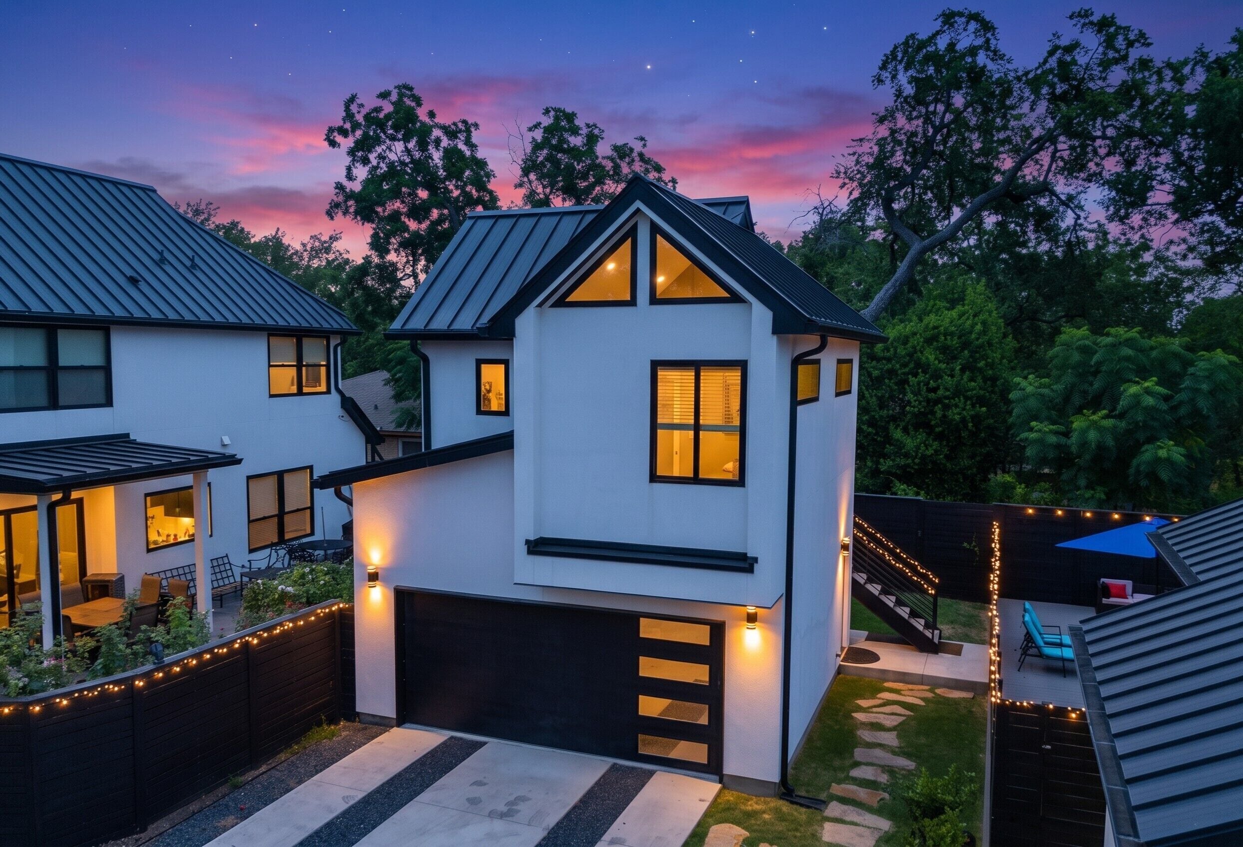 Ein zweistöckiges Haus mit Garage, überdachter Terrasse und einer Treppe zu einer Dachterrasse.