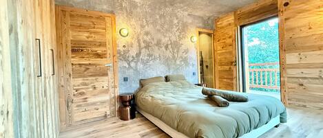 Una habitación con cama, paredes de madera y ventana con vistas.
