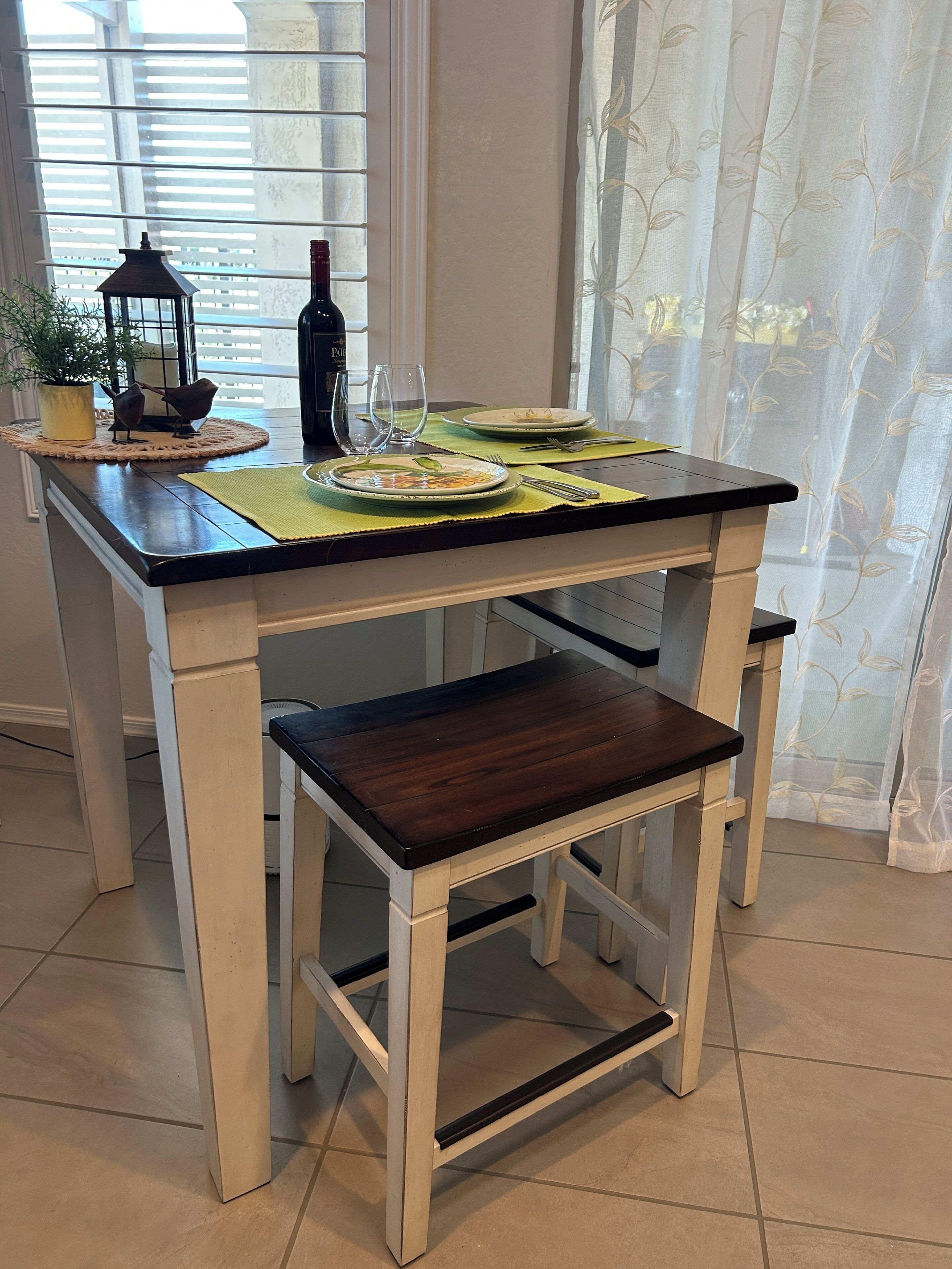 Et spisebord med dug, en vinflaske og glas.