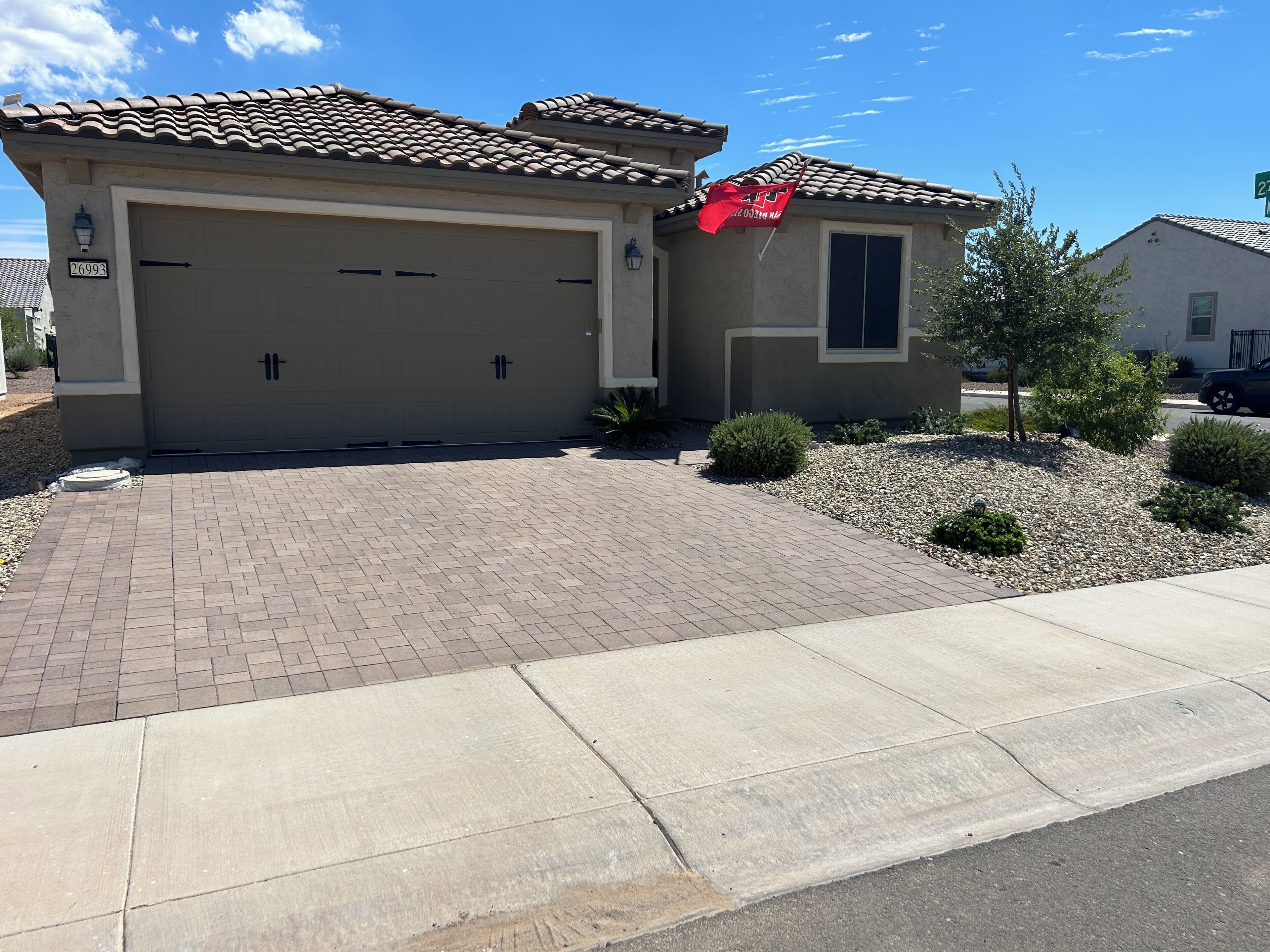 A residential garage with a clear driveway leading to the entrance.