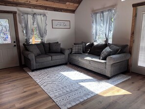 A cozy living room with a sectional sofa, patterned rug, and a framed quote on the wall. - 3 bedroom house in quiet Warsaw neighborhood sitting on Lake of the Ozarks! (Warsaw)