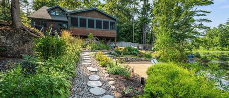 A two-story house with a stone pathway leading to the entrance.