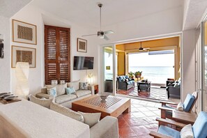 A living room with a sofa, coffee table, and a view of the ocean. - Private beachfront villa w/ private pool and chef (Puerto Vallarta)