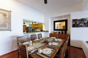 A dining area with a long wooden table set for a meal, flanked by wooden chairs. - Private beachfront villa w/ private pool and chef (Puerto Vallarta)