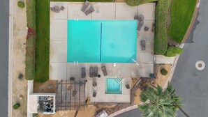 Una piscina en la azotea con sillones de descanso y una zona de piscina más pequeña.