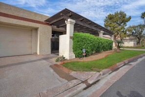 A residential house with a garage, a covered patio, and a well-maintained lawn. - Luxury Retreat Club La Quinta- Monthly Condo (La Quinta)