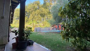 A covered patio area with potted plants, a swimming pool, and a fenced play area. - Villa Marilou: Quiet Location and Private Pool (Cestas)