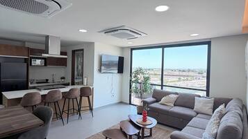 A modern living space with a kitchen, dining area, and seating area.