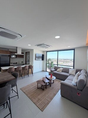 A modern living space with a kitchen, dining area, and seating area.