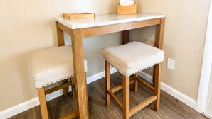 A corner room with a wooden table and two matching chairs.
