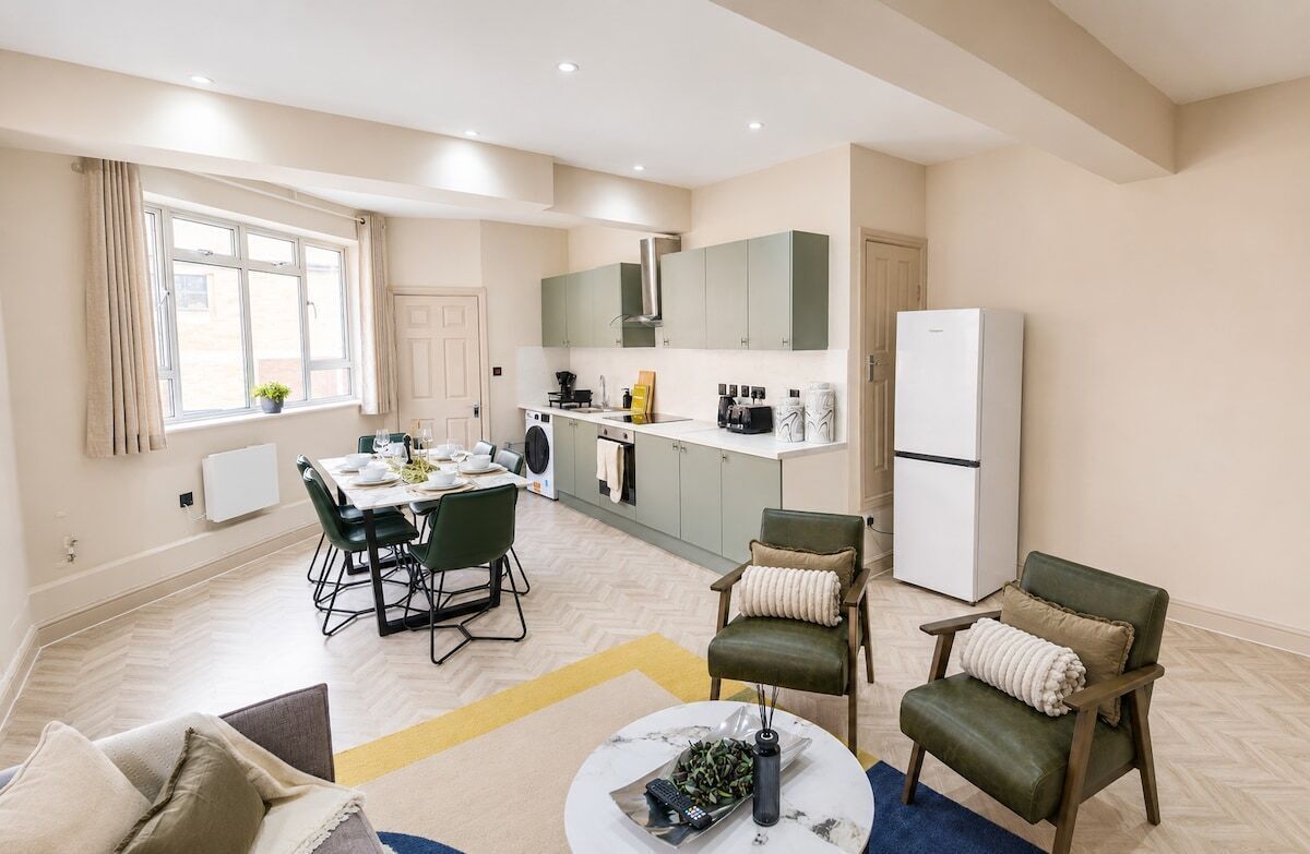 Una cocina moderna con comedor, refrigerador y cafetera.