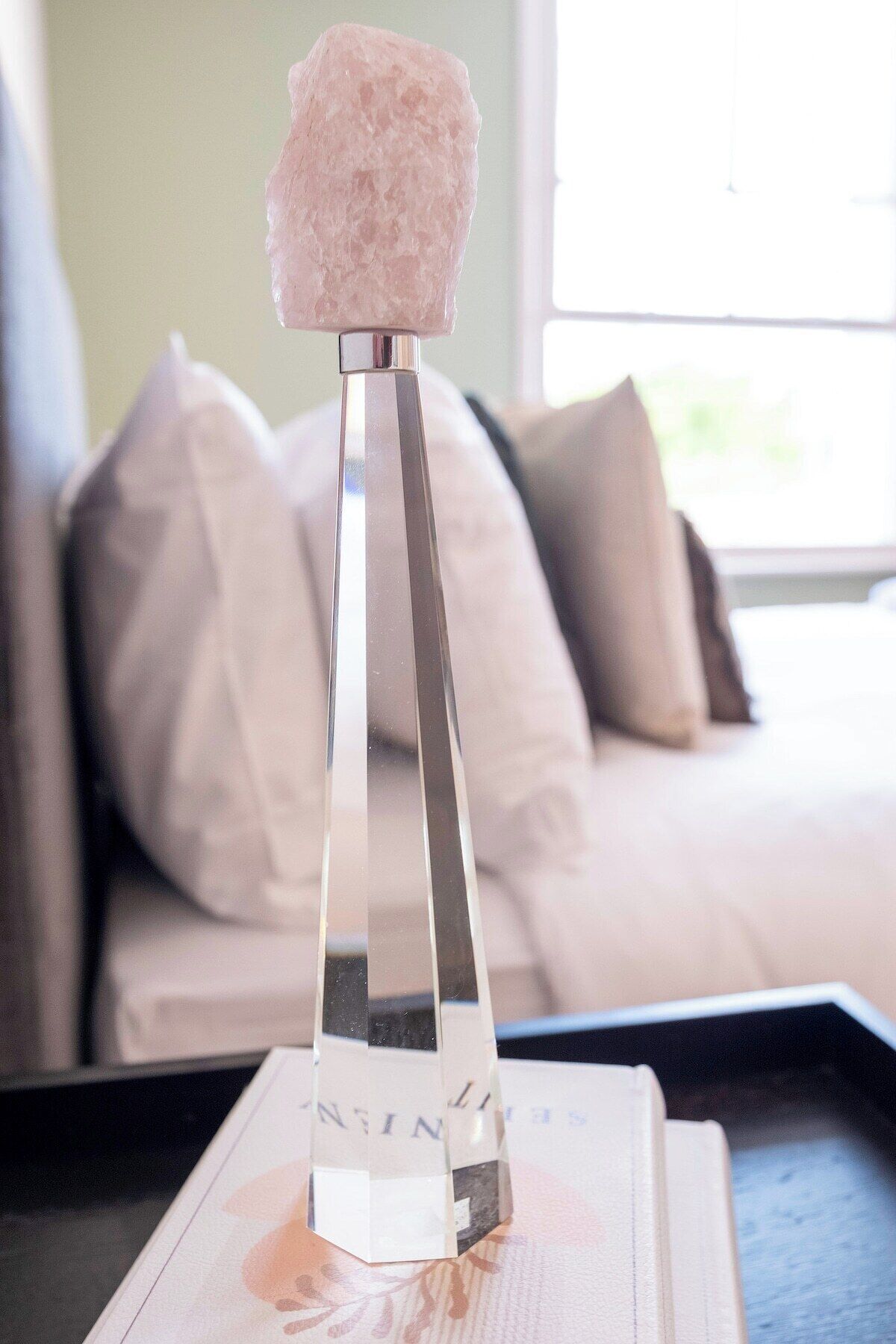 Un cristal de sel transparent, posé sur un support métallique, avec un livre en dessous.