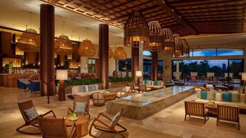 A spacious lobby with a bar area, seating arrangements, and a view of the outdoors.