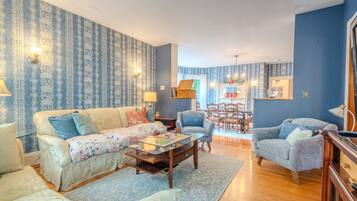 A living room with a sofa, armchairs, a coffee table, and a dining area with a table and chairs.
