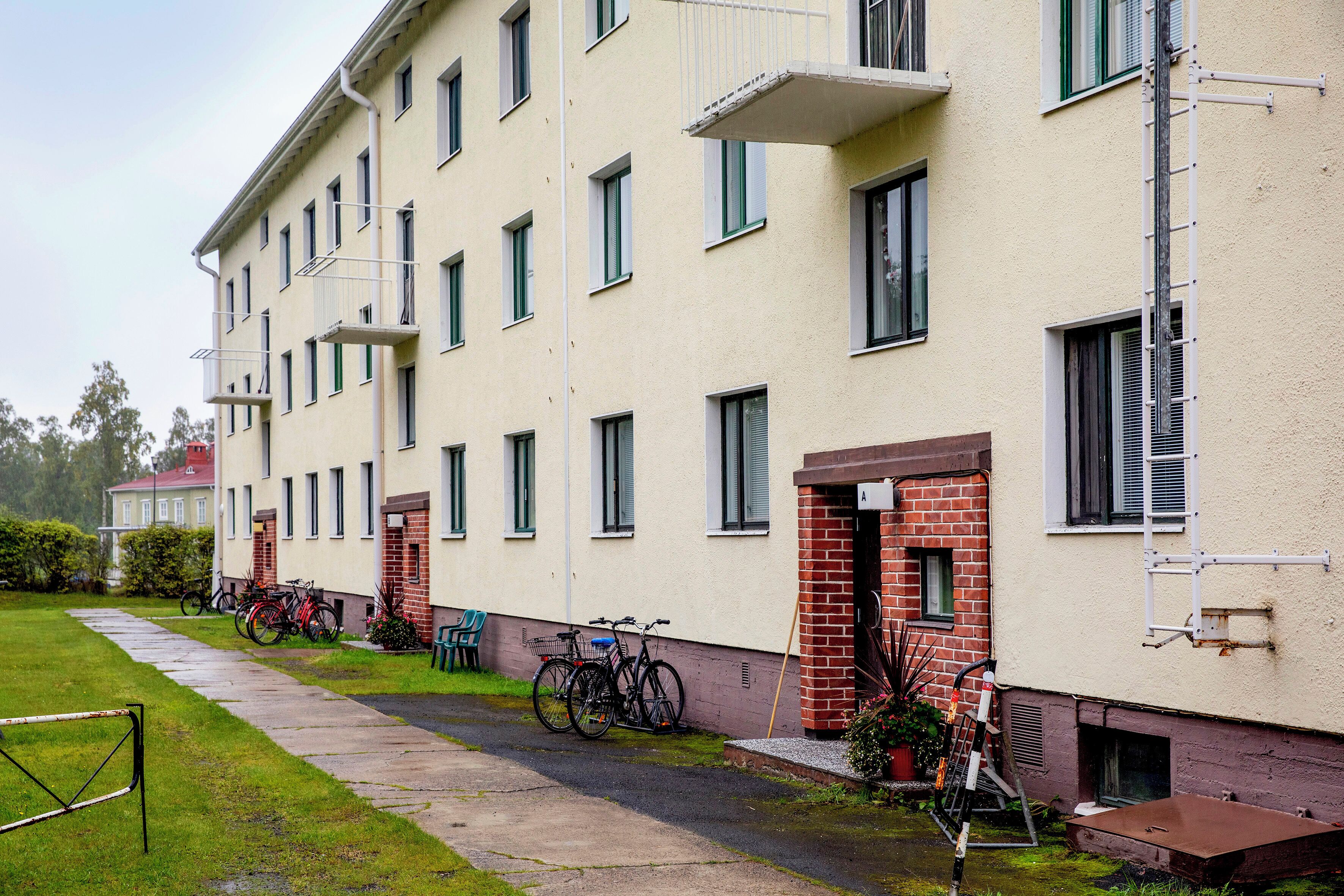 En bygning med flere etager, en flad facade, mange vinduer og en murstensindgang.