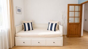 A single bed with storage drawers, a wooden door, and a framed picture on the wall. - Cosy Entire Apartment up to 4 guests - with free parking - 1 Min from Monaco (Beausoleil)
