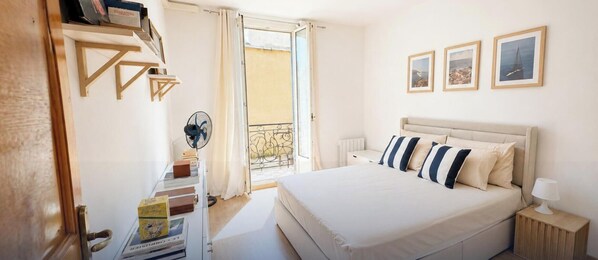 A bedroom with a bed, bedside table, lamp, and a window with curtains. - Cosy Entire Apartment up to 4 guests - with free parking - 1 Min from Monaco (Beausoleil)