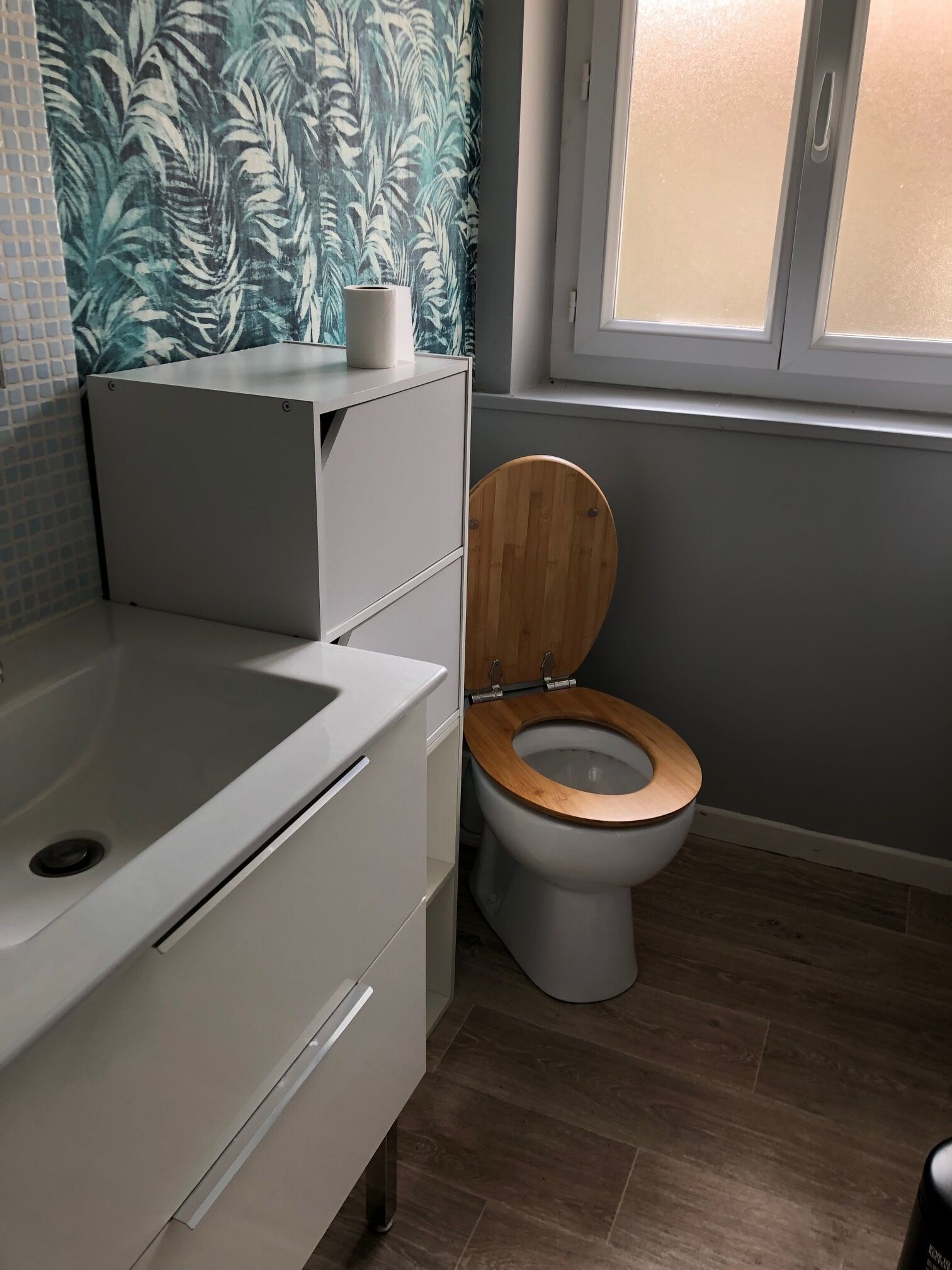 A bathroom with a toilet, a sink, and a shower area.