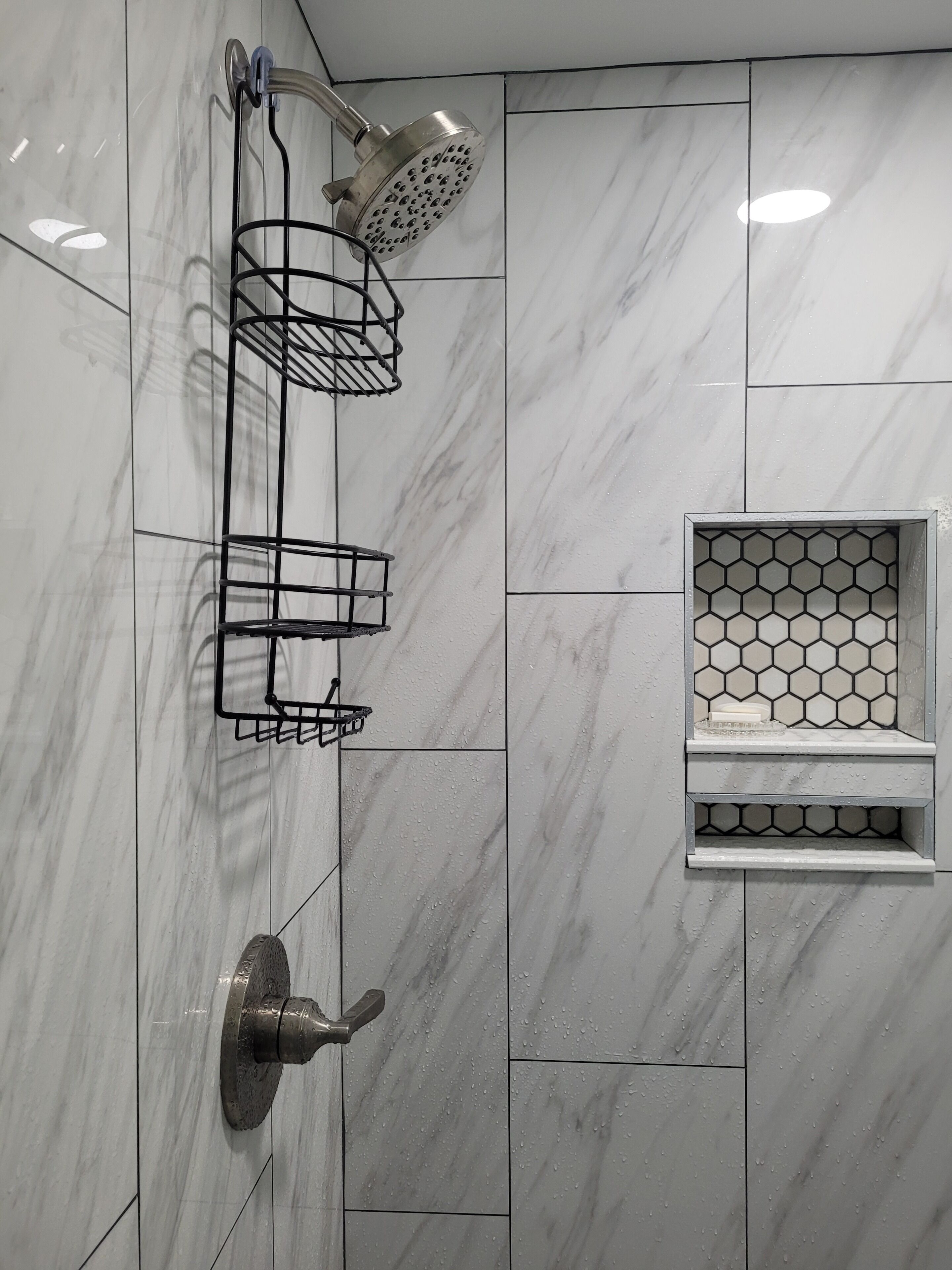 Ein Badezimmer mit Dusche, Handtuchhalter und Seifenschale.