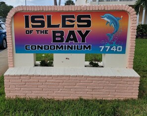 A sign for 'Isles of the Bay Condominium' with a contact number 7740. - Quaint 1-bedroom condo in St. Pete Beach, 3 blocks from Beach, on the bay. (St. Pete Beach)