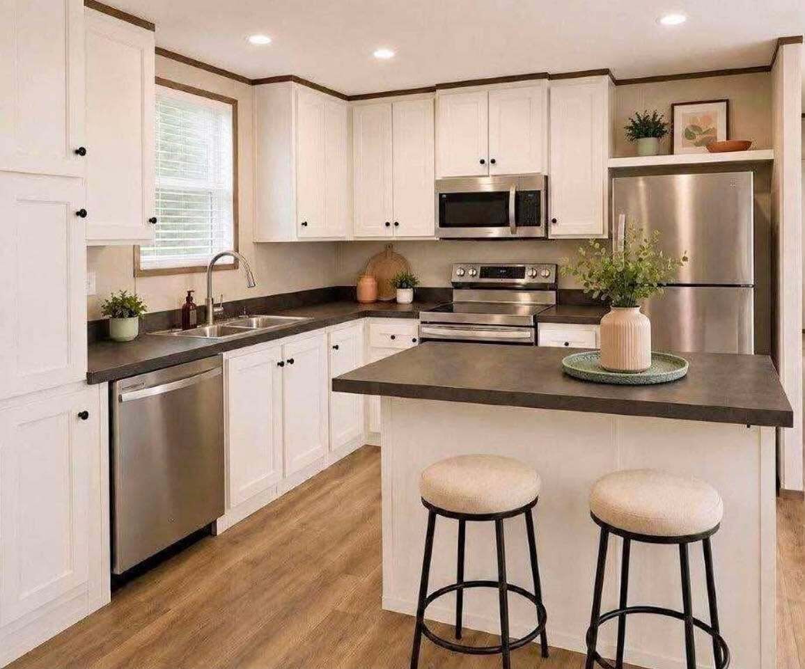 A modern kitchen with white cabinets, stainless steel appliances, a central island with stools, and a window with blinds.