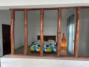 A room with a bed, a nightstand, and a lamp.