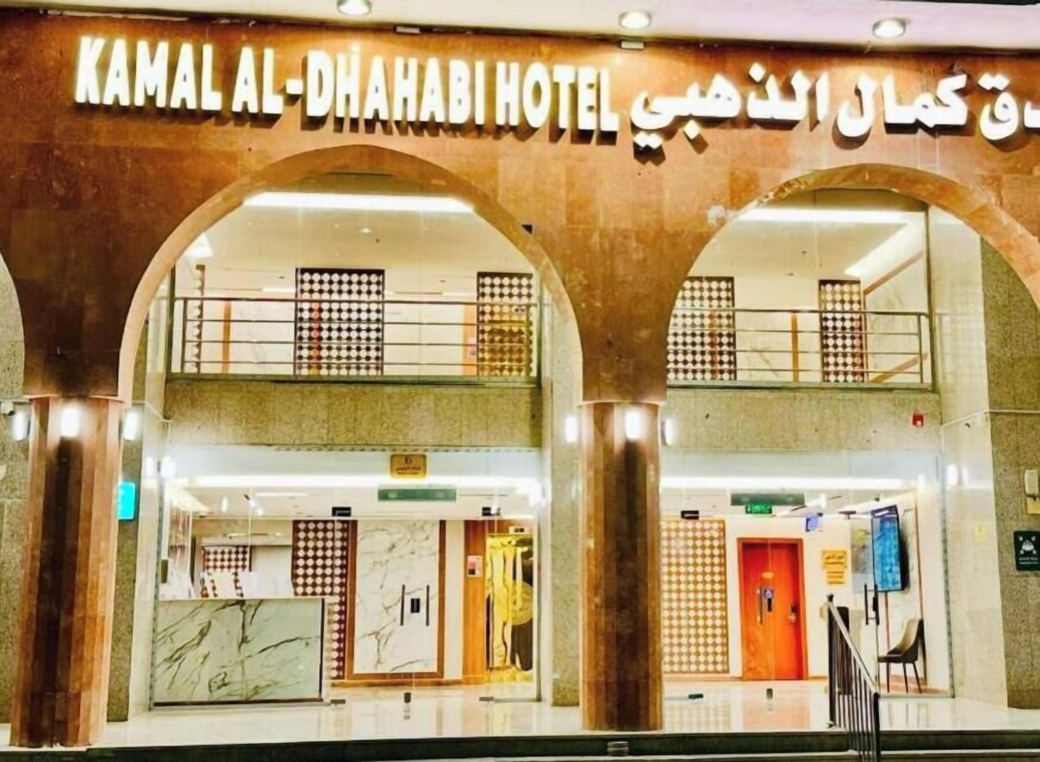 Exterior de l'Hotel Kamal Al-Dhahabi, amb una arcada central, diverses plantes i una entrada visible.