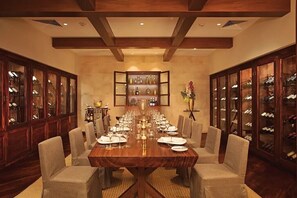 A formal dining room with a long table set for a meal, flanked by wine cabinets. - Escape into luxury at Secrets® Cap Cana Resort & Spa, a AAA Five Diamond Resort! (Punta Cana)