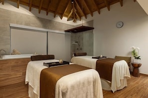 A modern spa room with two beds, a large mirror, a shower area, and a wooden ceiling. - Escape into luxury at Secrets® Cap Cana Resort & Spa, a AAA Five Diamond Resort! (Punta Cana)