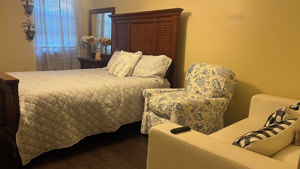 A bedroom with a large bed, a chair, and a sofa. - Your Ideal Stay Near the Stockyards (Fort Worth)