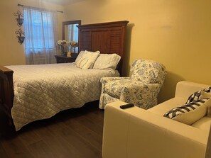 A bedroom with a large bed, a chair, and a sofa. - Your Ideal Stay Near the Stockyards (Fort Worth)