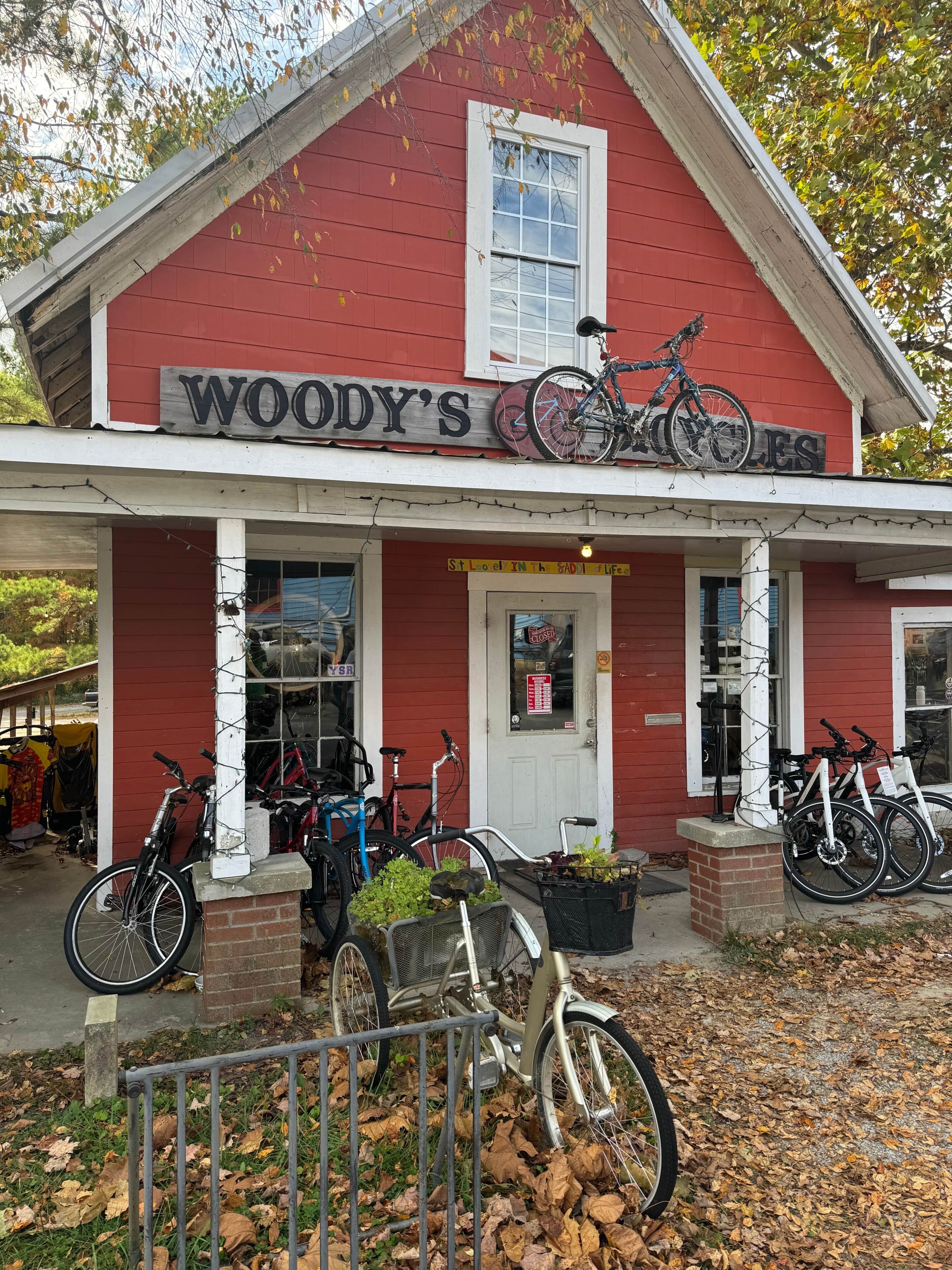 A red building with a sign reading 'WOODY'S COOKIES' and bicycles parked outside.
