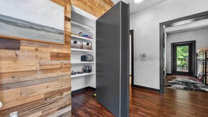 A modern interior with wooden paneling, a built-in shelf unit, and a dark-colored door. - The Prominence | Luxury TH + Double Rooftop Lounge (Tracy City)