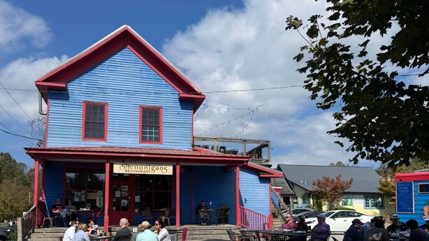 A blue building with a red roof and a sign that reads 'Shenanigans Restaurant.' - The Prominence | Luxury TH + Double Rooftop Lounge (Tracy City)