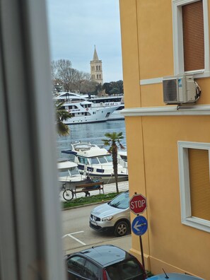 Blick auf eine Marina mit vertäuten Booten, einem Stoppschild und einem Gebäude mit Klimaanlage.