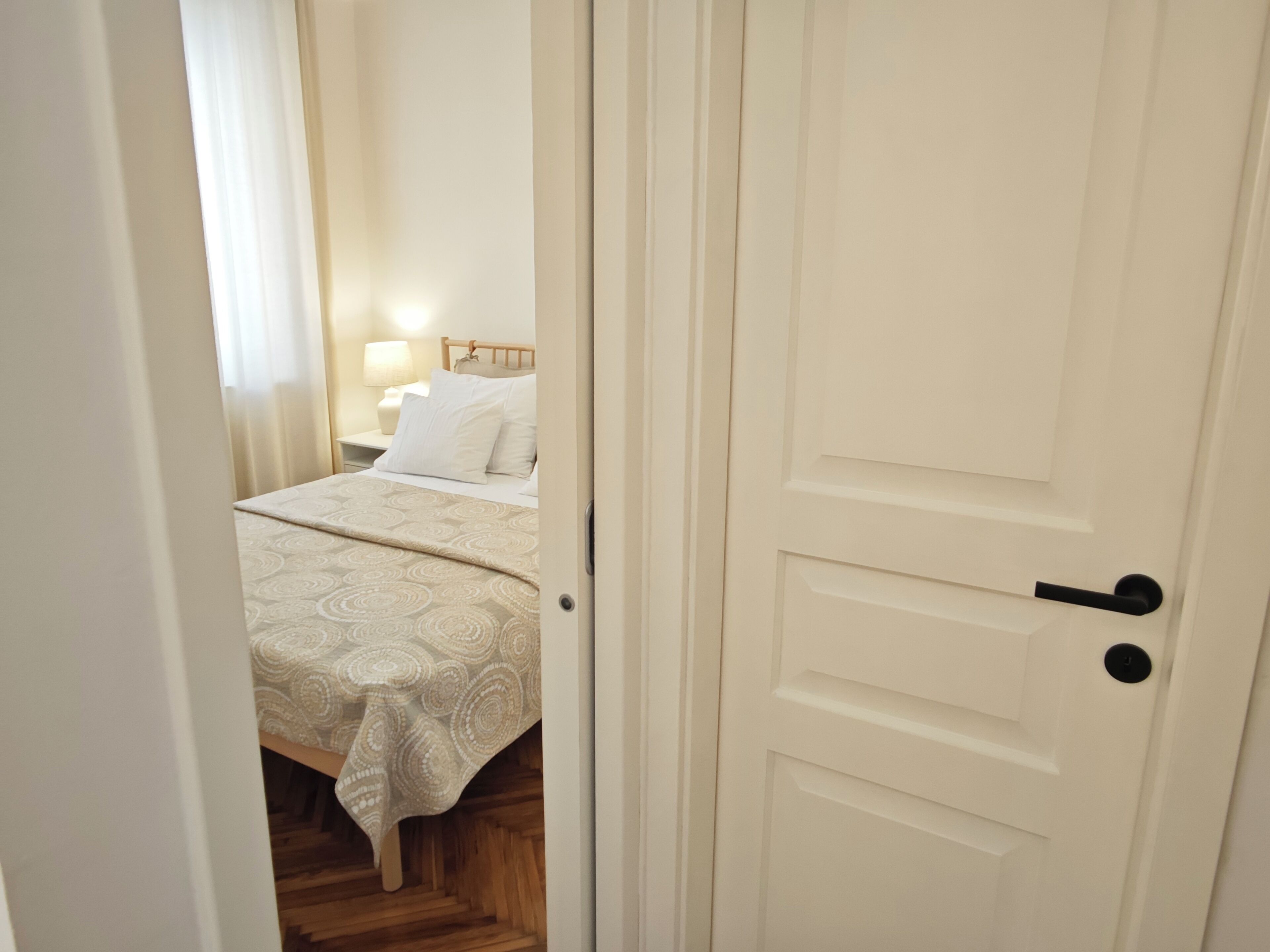 Ein Schlafzimmer mit einem Bett, einem Nachttisch und einer Lampe.