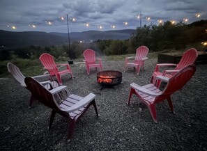 A fire pit surrounded by Adirondack chairs with a mountainous backdrop. -  Farmhouse in Windsor. A scenic countryside escape. (Windsor)