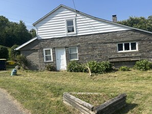 A two-story house with a stone facade and a white roof. -  Farmhouse in Windsor. A scenic countryside escape. (Windsor)