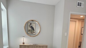 Um quarto com uma cama, uma cômoda, um quadro na parede e uma janela.