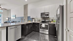 A modern kitchen with stainless steel appliances, a dishwasher, and a microwave. - Modern Uptown 1BR | Sleeps 4 | Near Klyde Park (Dallas)