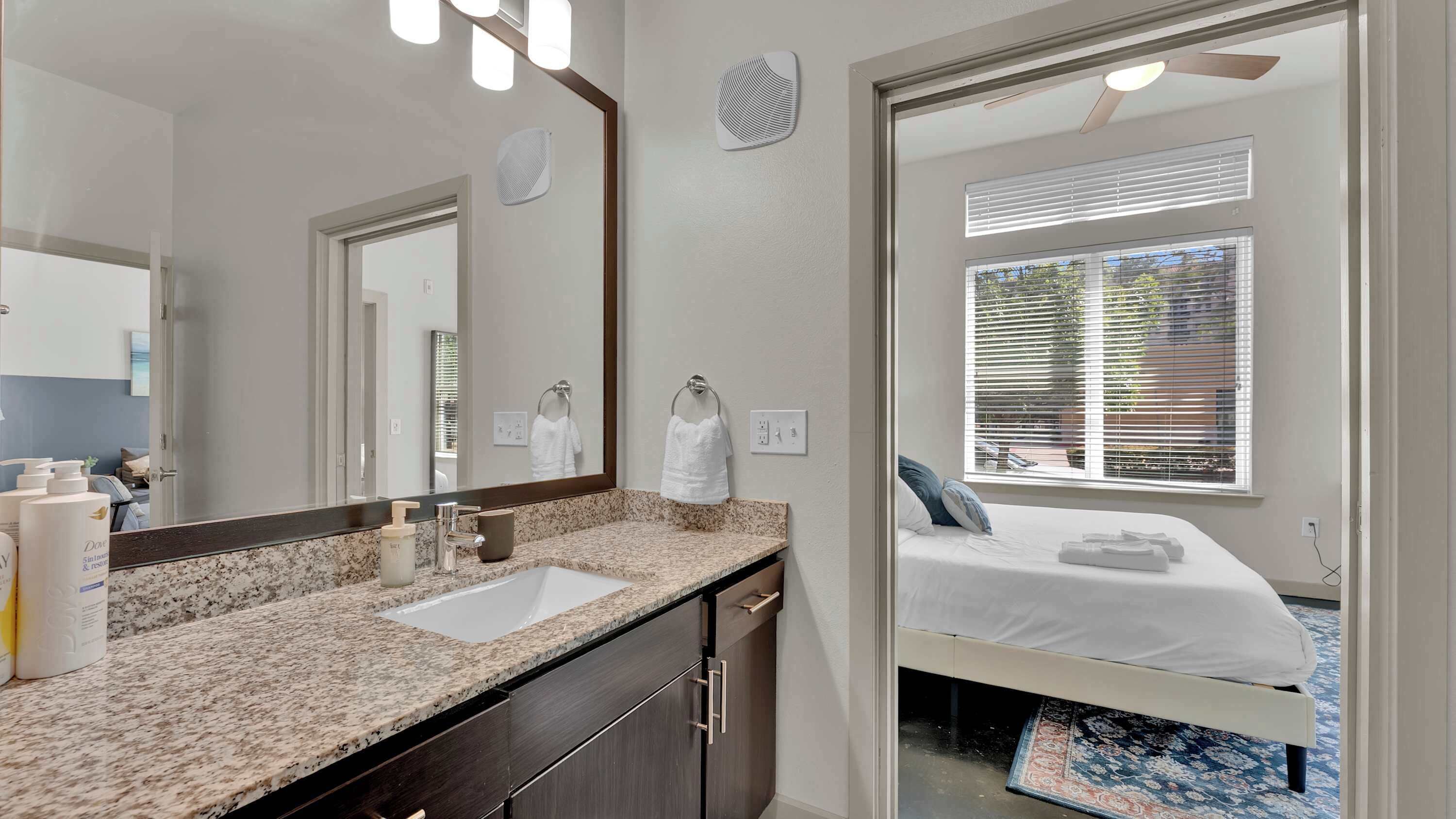 A bathroom with a double sink, a mirror, and a towel rack.