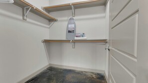 A room with a built-in ironing board, a shelf with a box, and a door. - Uptown Escape 2BD | Sleeps 12 | Parking (Dallas)