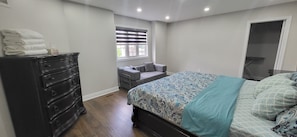 A bedroom with a bed, dresser, window, and a door. - Cozy 3BR Brampton (Brampton)