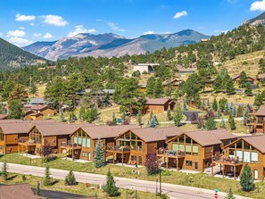 Ein Resort mit mehreren Holzhütten, jede mit einem Balkon und großen Fenstern.
