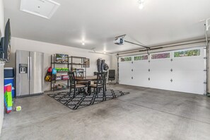 Eine Garage mit Esstisch, Stühlen und einem Kühlschrank.