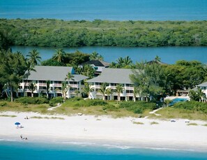 Ein Küstenhotel mit mehreren Gebäuden, einem Strand und freiem Blick auf den Ozean.