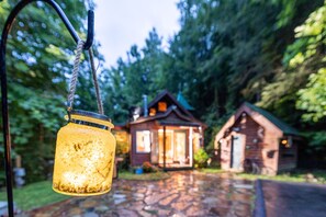 A rustic cabin with a stone pathway leading to it, surrounded by trees. - Storybook in the Smokies - Secluded, Free Pet, Hot Tub, BBQ, Washer & Dryer (Pigeon Forge)