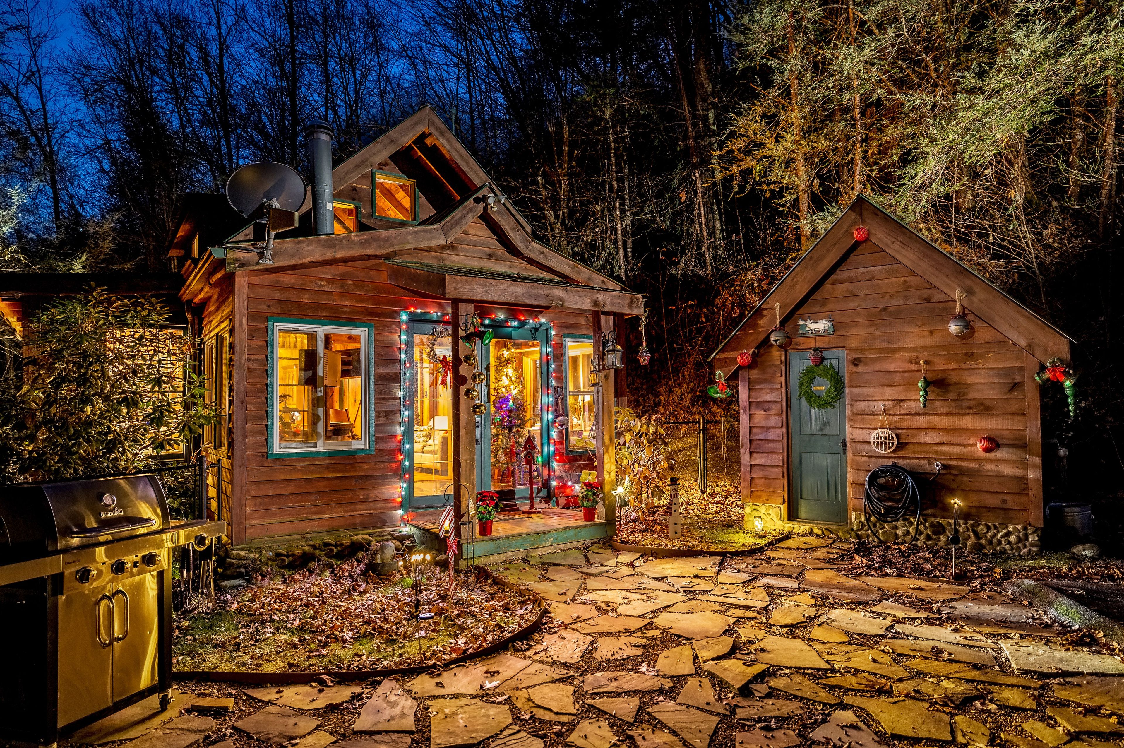 A wooden cabin with a stone pathway leading to it, surrounded by trees.