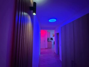 A hallway with a wooden slat wall and a ceiling light fixture.